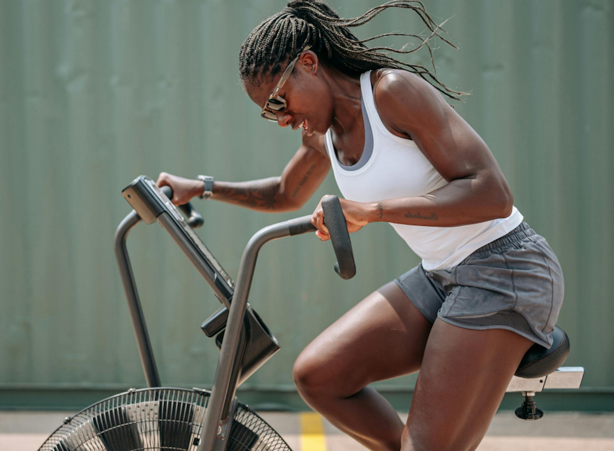 Woman riding air bike wearing Estacado sunglasses