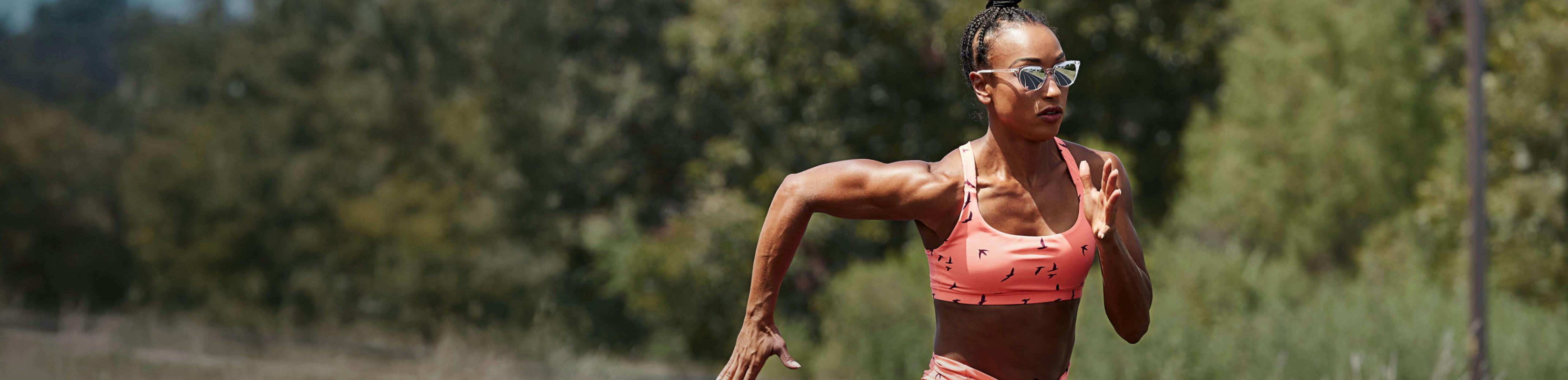 Woman running in pink top and Lola sunglasses