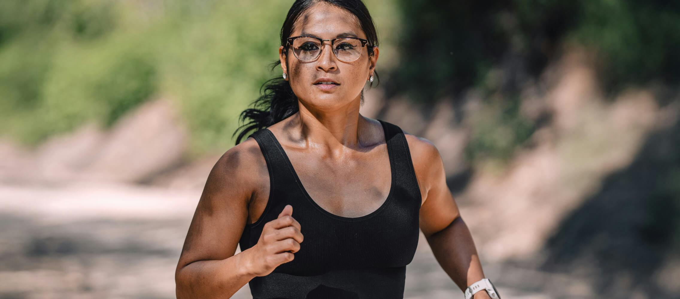 Woman running in the woods in Cambridge eyeglasses