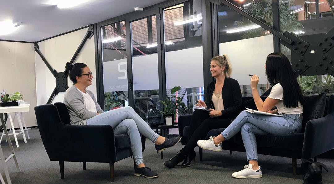 Three people sitting down having a casual meeting