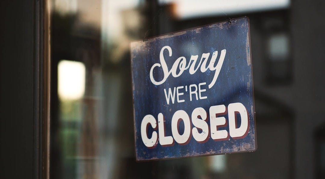 retro sign hanging in the doorway of a business saying sorry we're closed