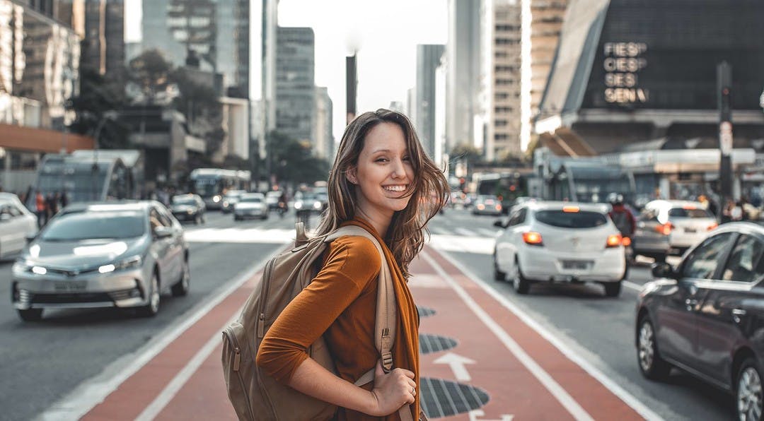 travelling girl on city street with cars