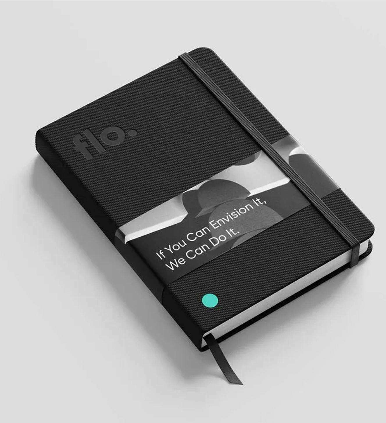 Black notebook with Flo logo embossed on it, wrapped in a sleeve with a black and white 3D render and the text, 'If You Can Envision it, We Can Do It'.