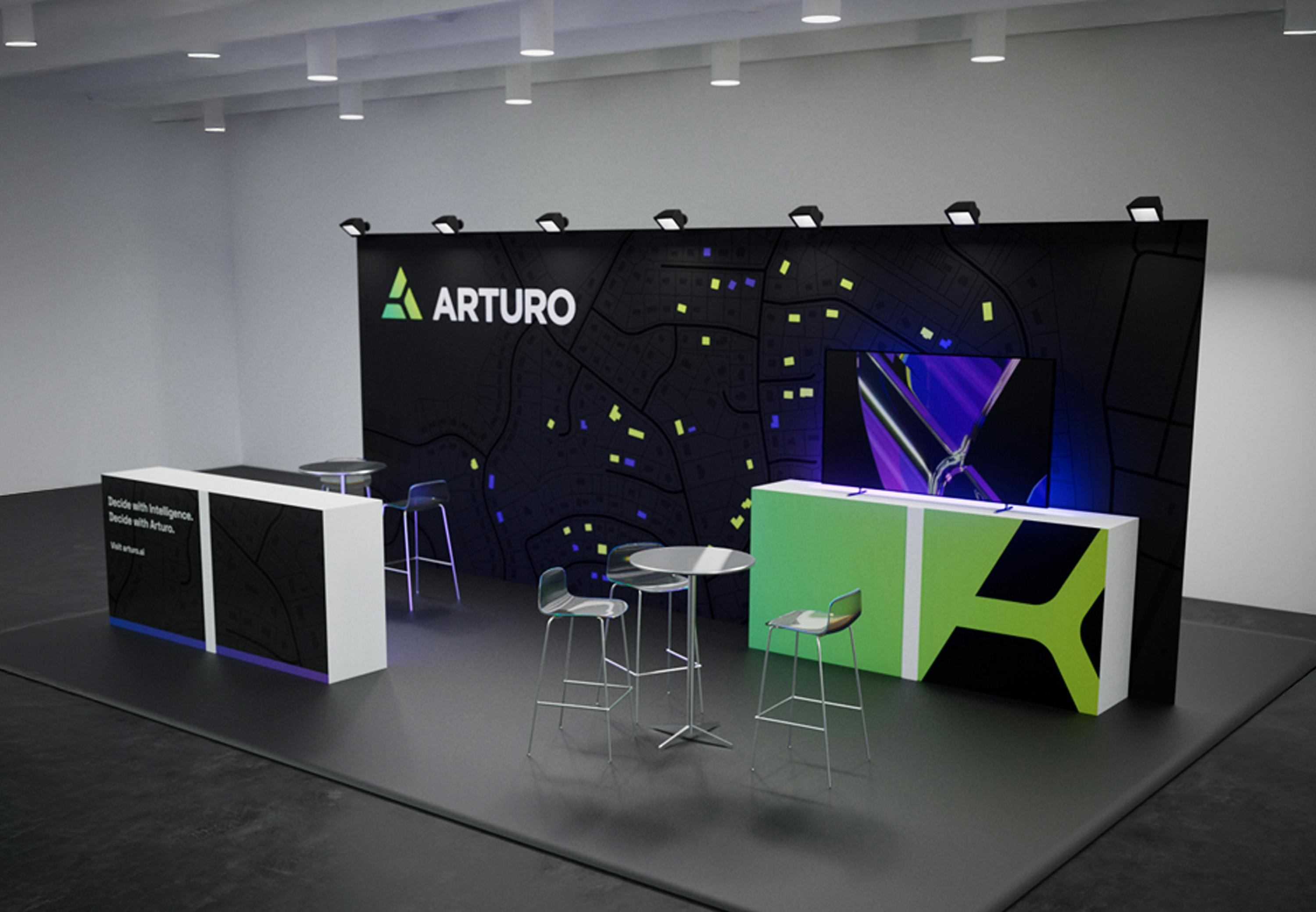The Arturo trade booth with a pattern-designed backdrop, arturo logo, and green, purple, and black branded cabinets