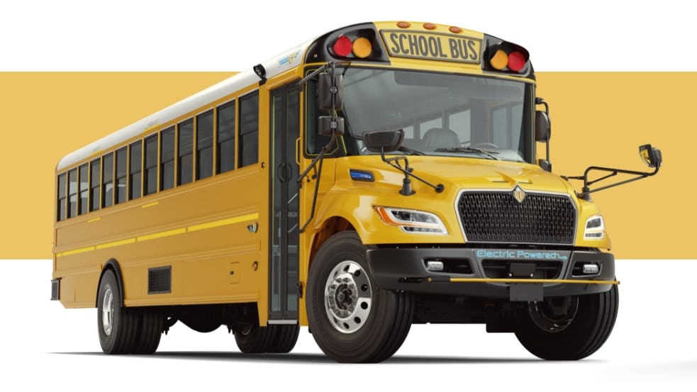 Modern yellow school bus labeled Electric Powered, promoting clean energy transportation