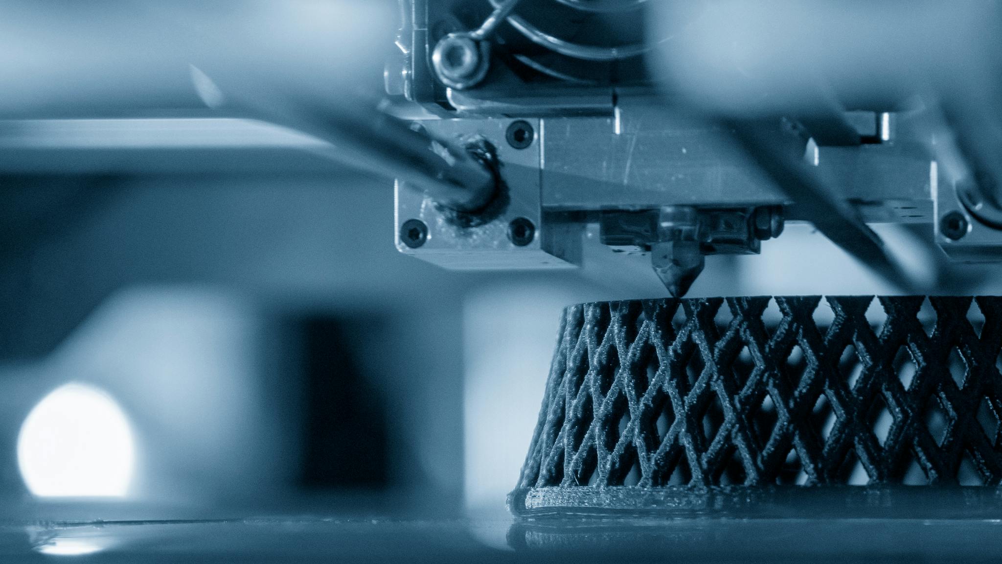 3D printer in action creating a detailed lattice structure, highlighting advanced manufacturing technology.