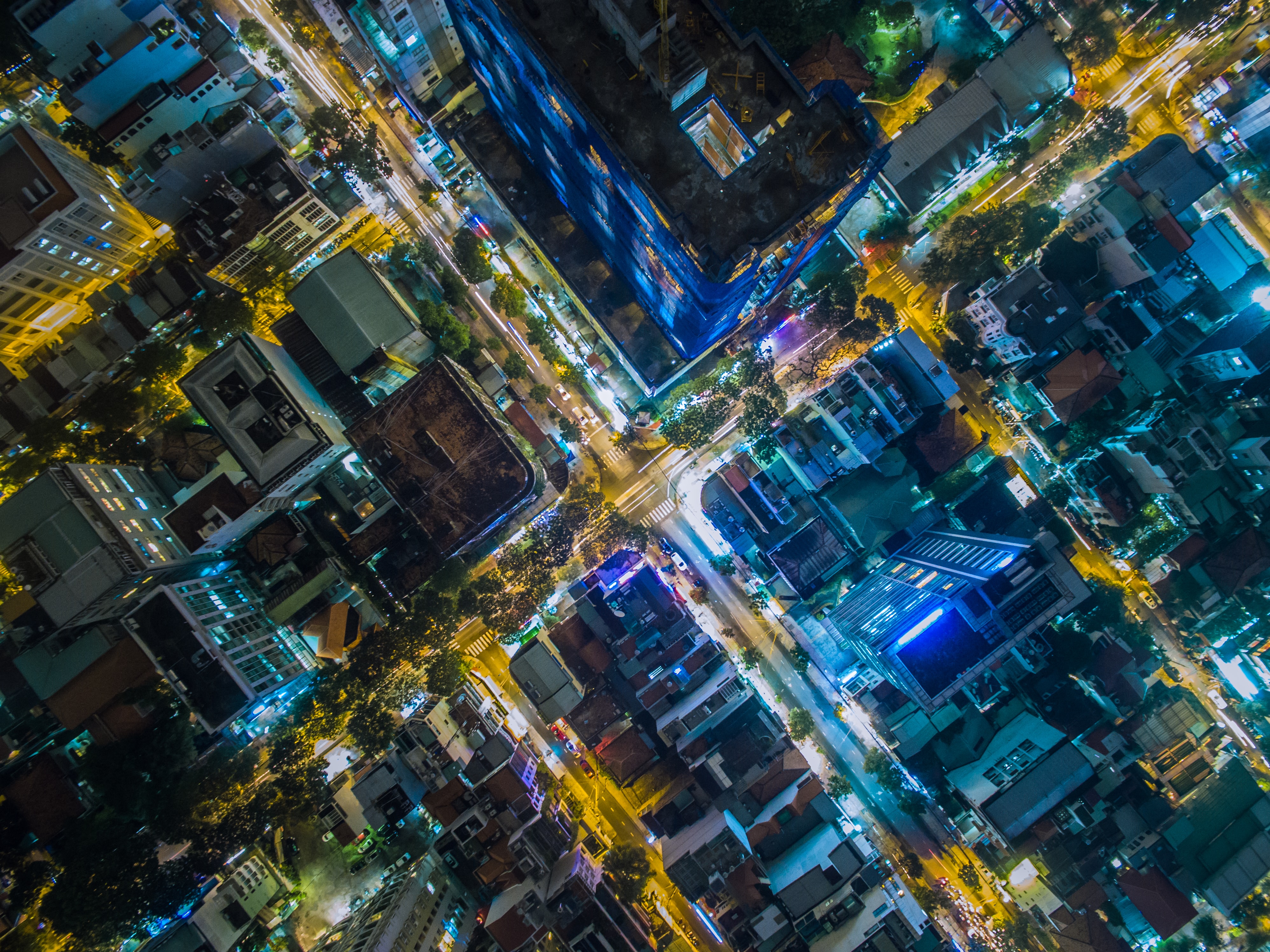 Colorful cityscape intersection at night shot from directly above.