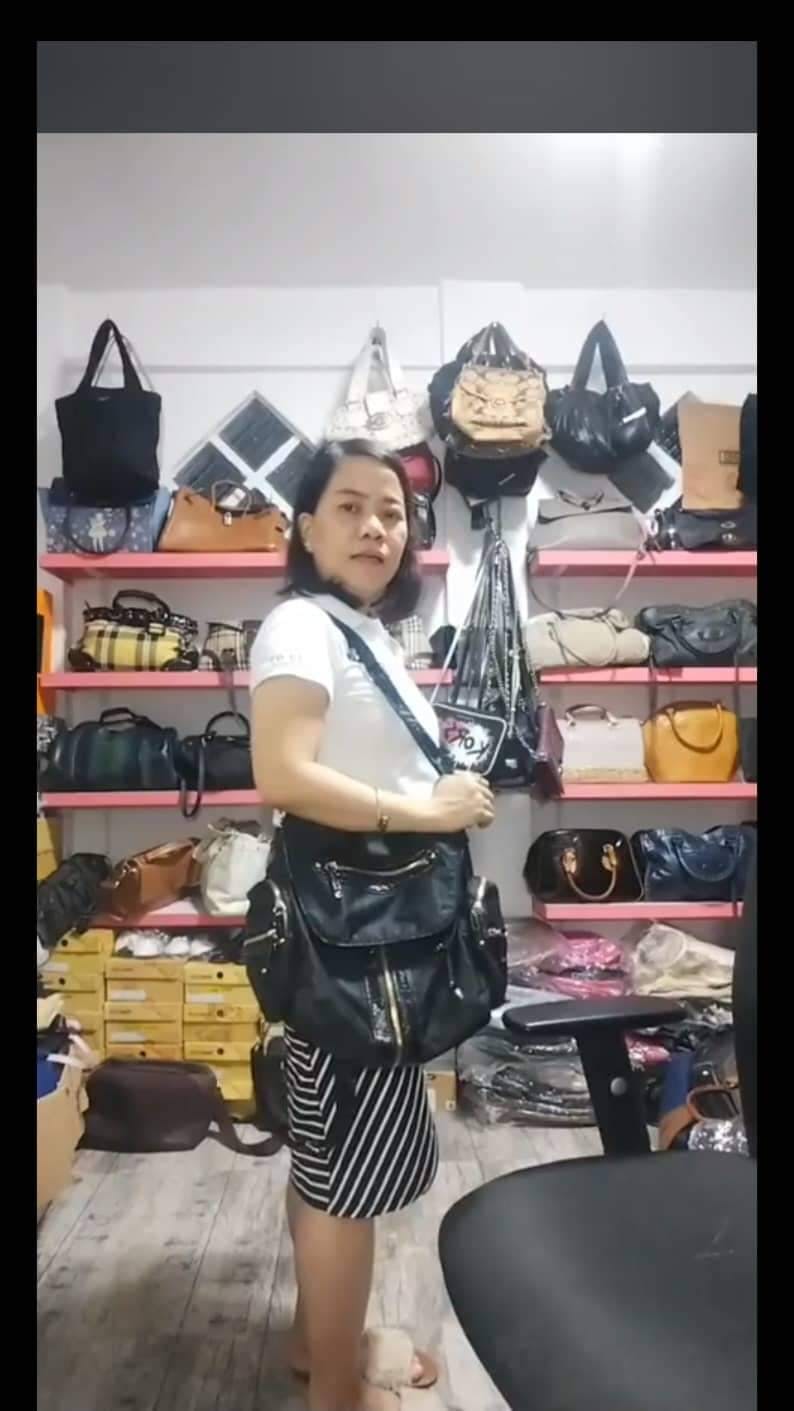 Bheng  Bue, owner/operator of Preloved Matters Atbp posing in her reselling shop full of preloved handbags