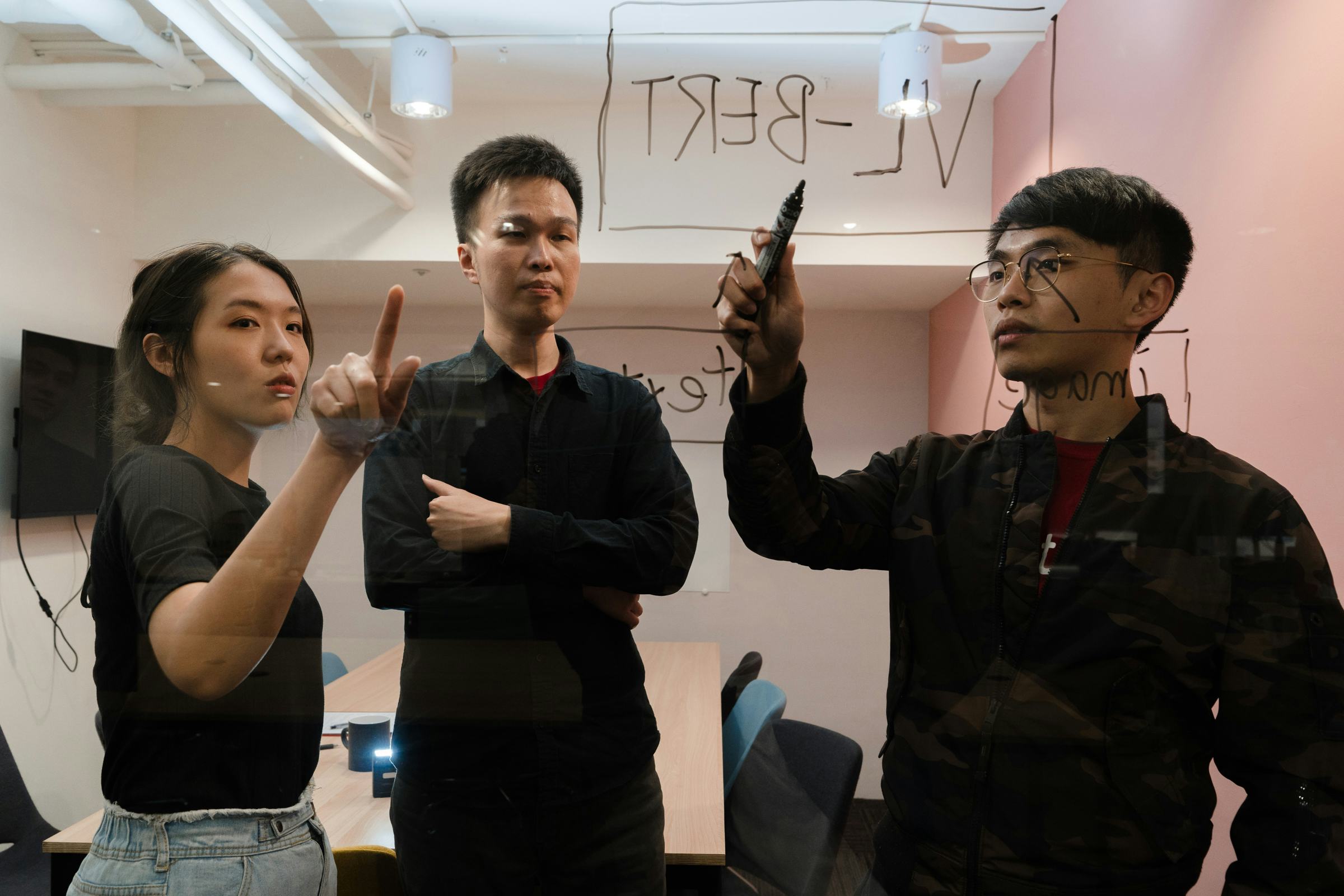 Rosetta AI founders Steeve Huang (CTO), Alice Li (COO) and Daniel Huang (CEO) using a window to sketch out plans for their recommender system 