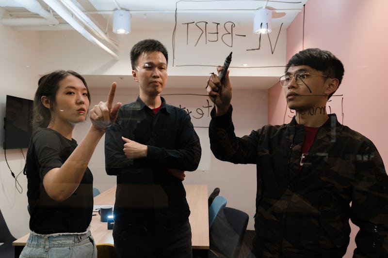 Rosetta AI founders Steeve Huang (CTO), Alice Li (COO) and Daniel Huang (CEO) using a window to sketch out plans for their recommender system