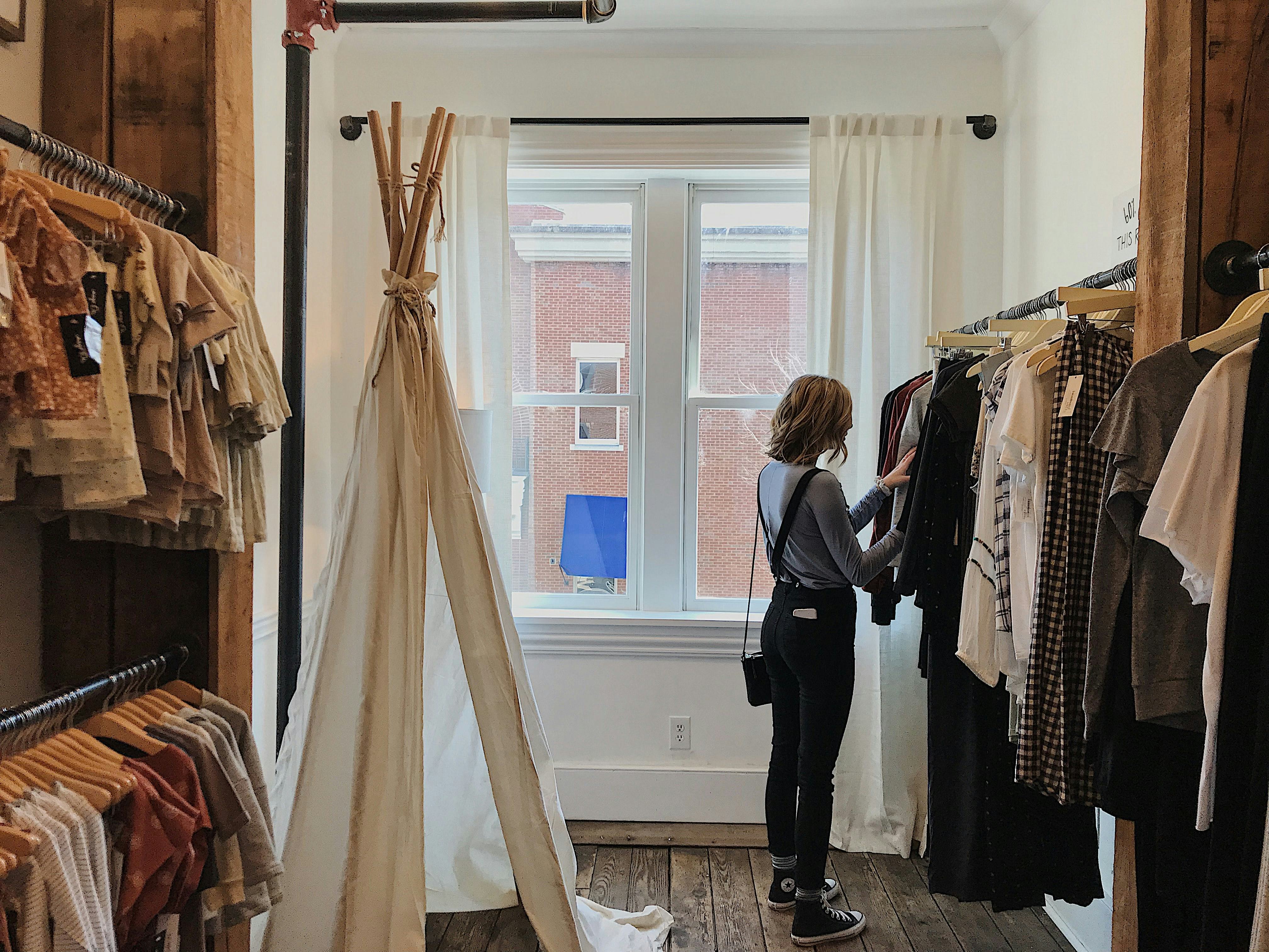 Lady browsing clothes in a hip fashion boutique.