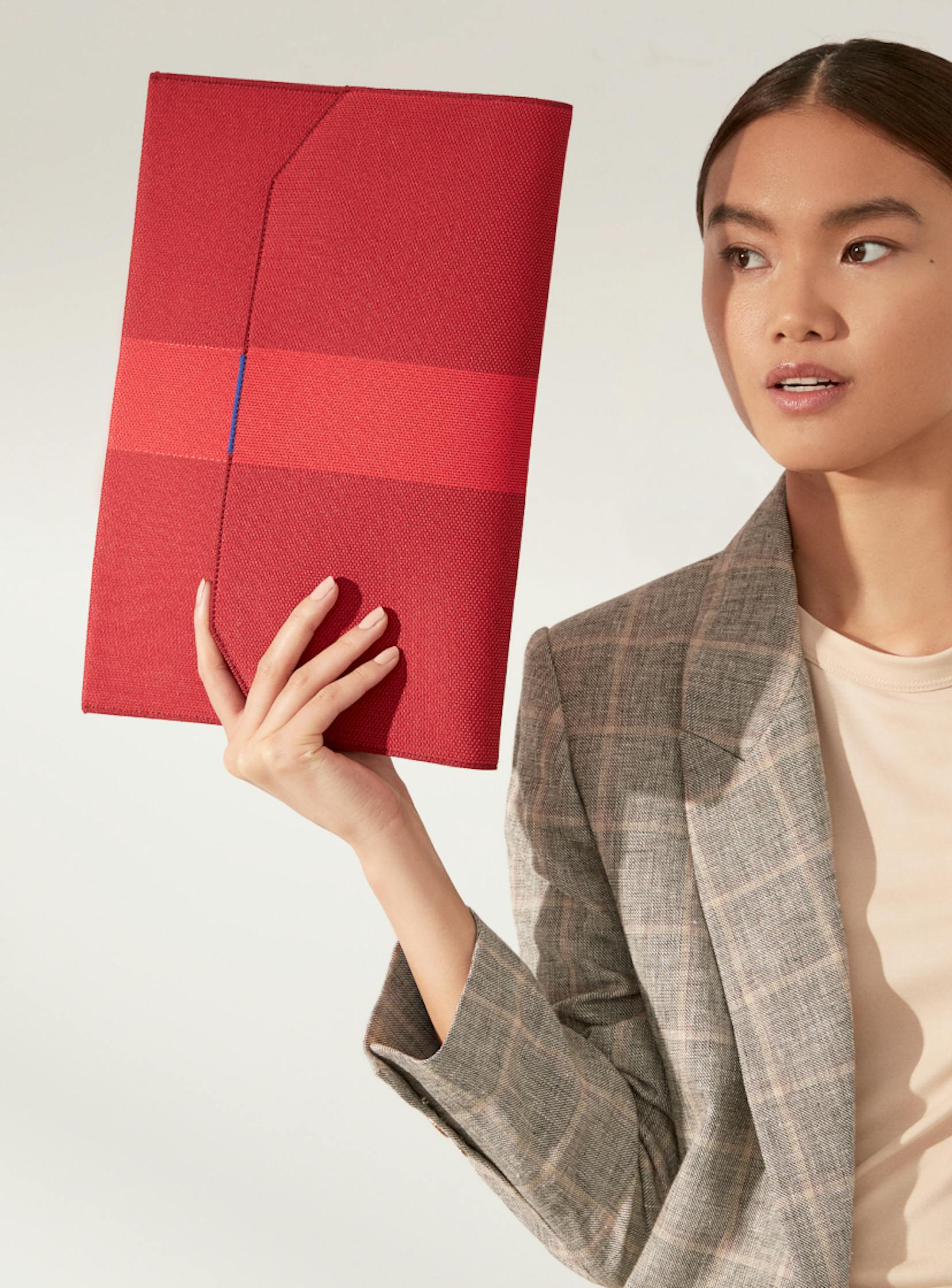The Portfolio in Ruby Red carried by a model.