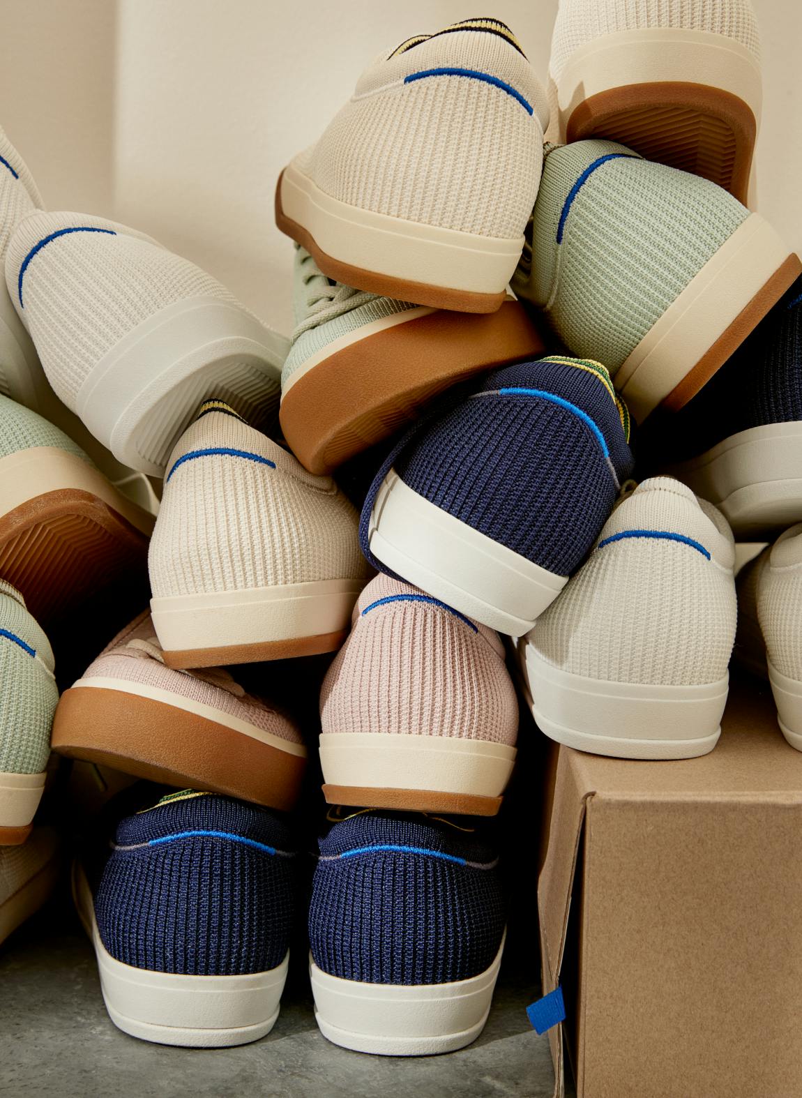 A stack of The Lace Up in Navy, Lilac, Vanilla, Bright White and Spearmint, shown from the back with halo detail on heel.