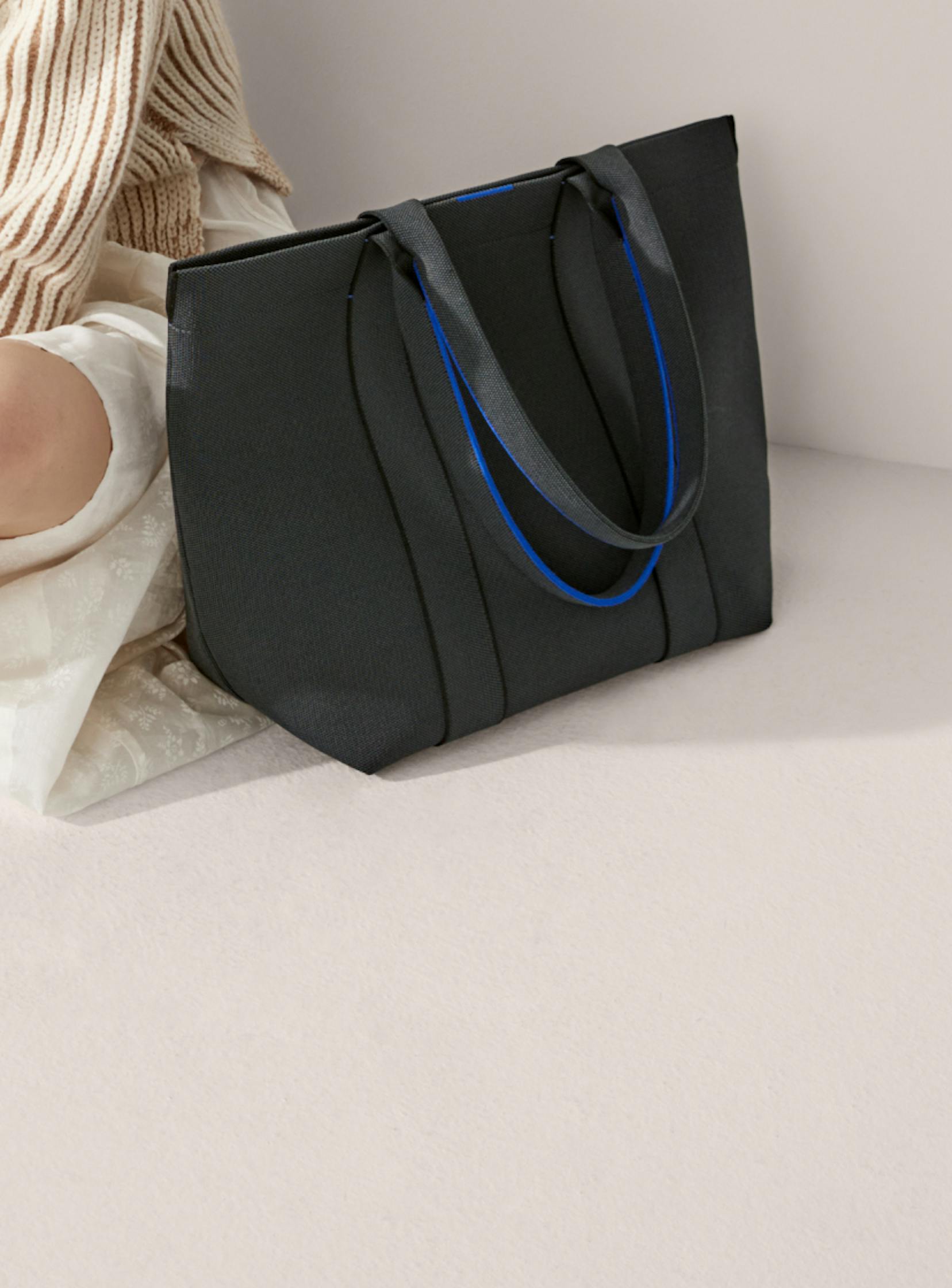 The Knot in Black shown on-model alongside The Essential Tote in Slate Black.