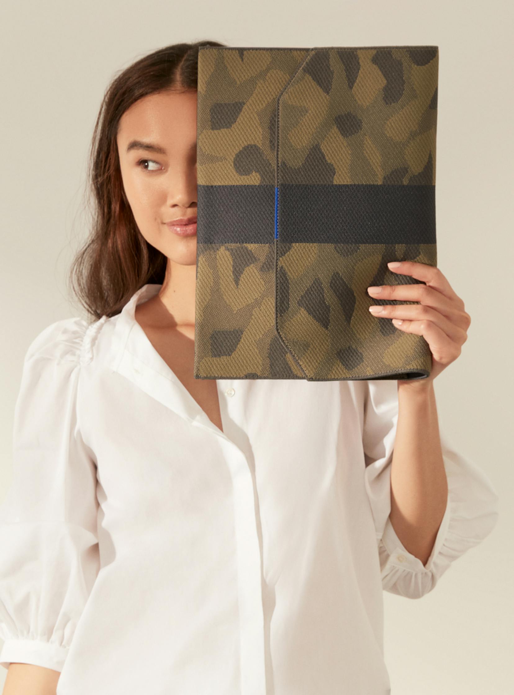 The Portfolio in Sage Camo carried by a model.