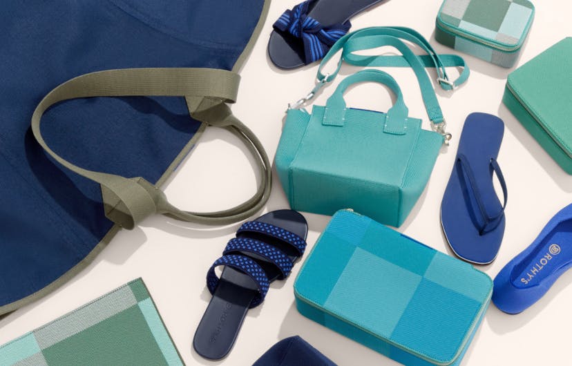 A laydown of The Reversible Tote in Navy & Pink, The Mini Handbag in Juniper Green, The Mini Catchall in Juniper Madras, The Mid Catchall in Juniper Green, The Large Catchall in Caribbean Madras, The Essential Pouch in Juniper Madras, The Flip in Splash, The Flat in Cornflower, The Knot in Cobalt Stripe and The Triple Band in Cobalt Basket Stitch.