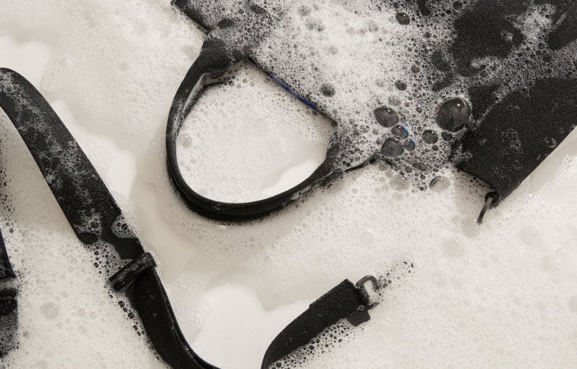 The Handbag in Total Black shown wet with soap suds.