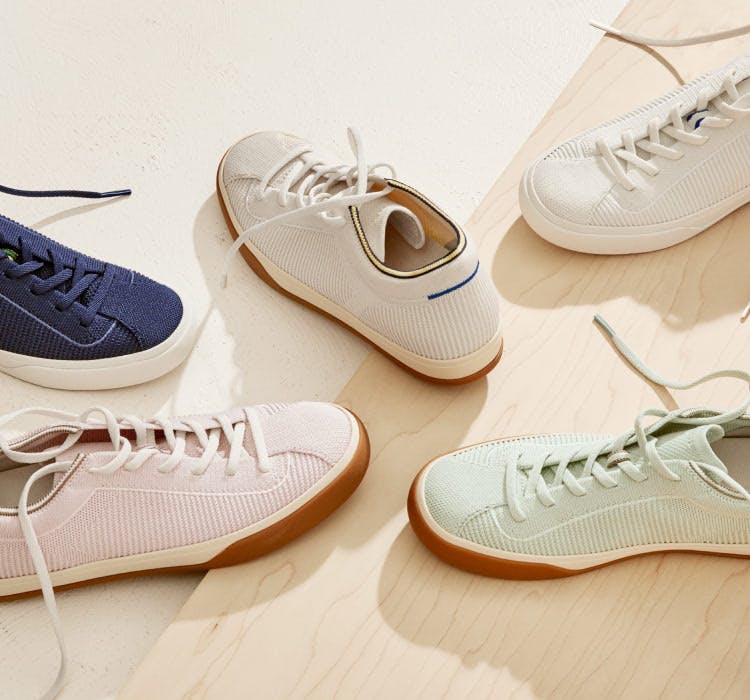An assortment of The Lace Up in Vanilla, Bright White, Spearmint, Lilac and Navy shown from the top against a wooden background.
