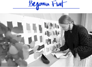 Black and white image of a member of the Rothy’s team holding a shoe. 