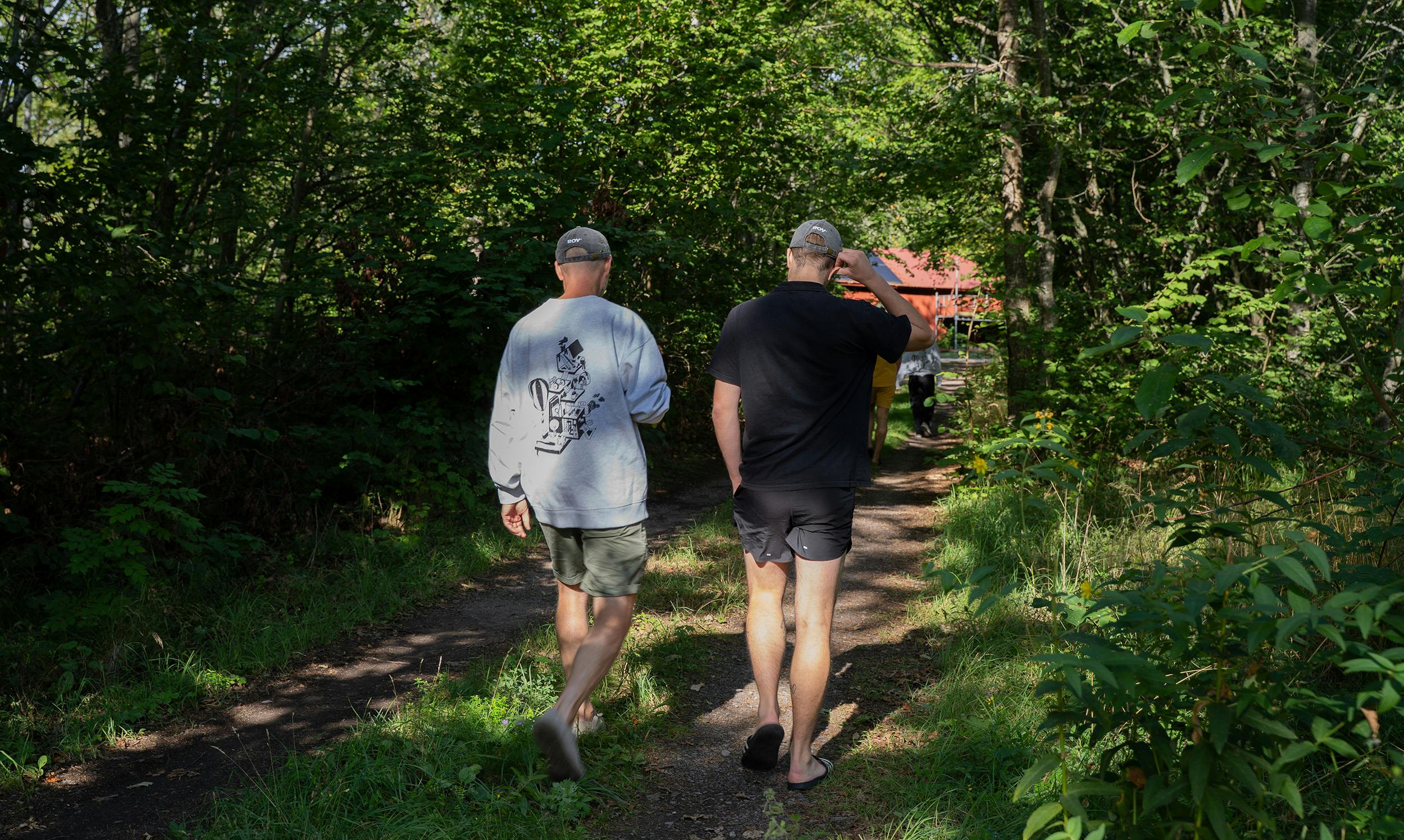 Två personer som går i skog, En med grå Roymerch tröja