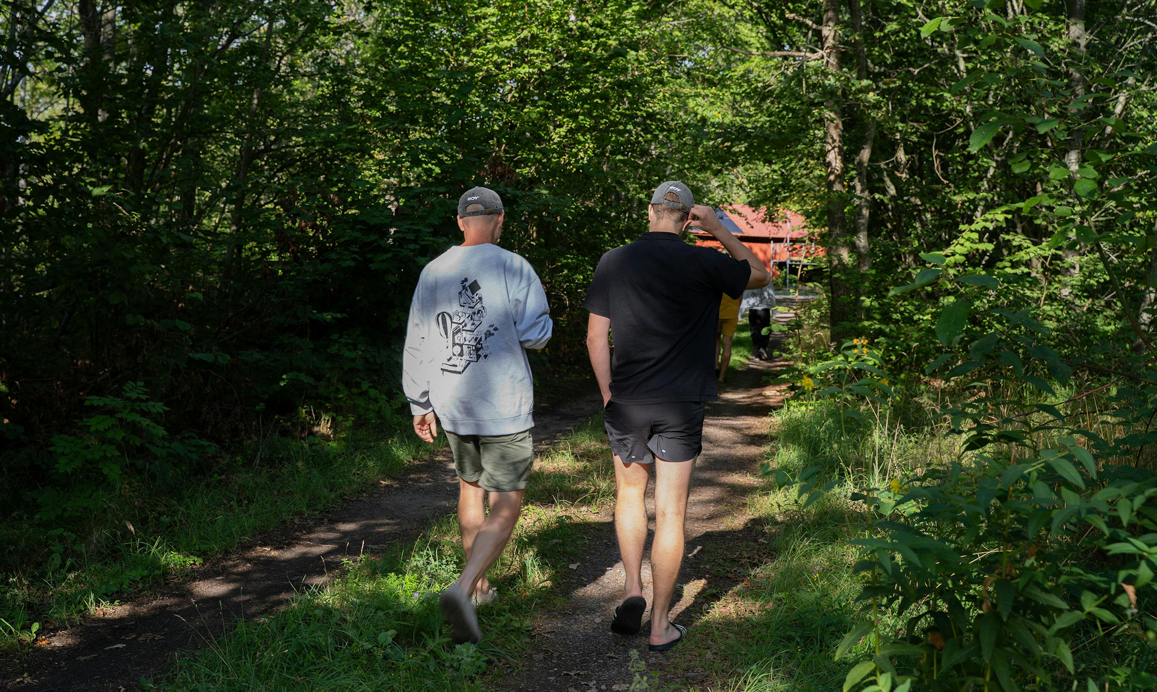 Två personer som går i skog, En med grå Roymerch tröja