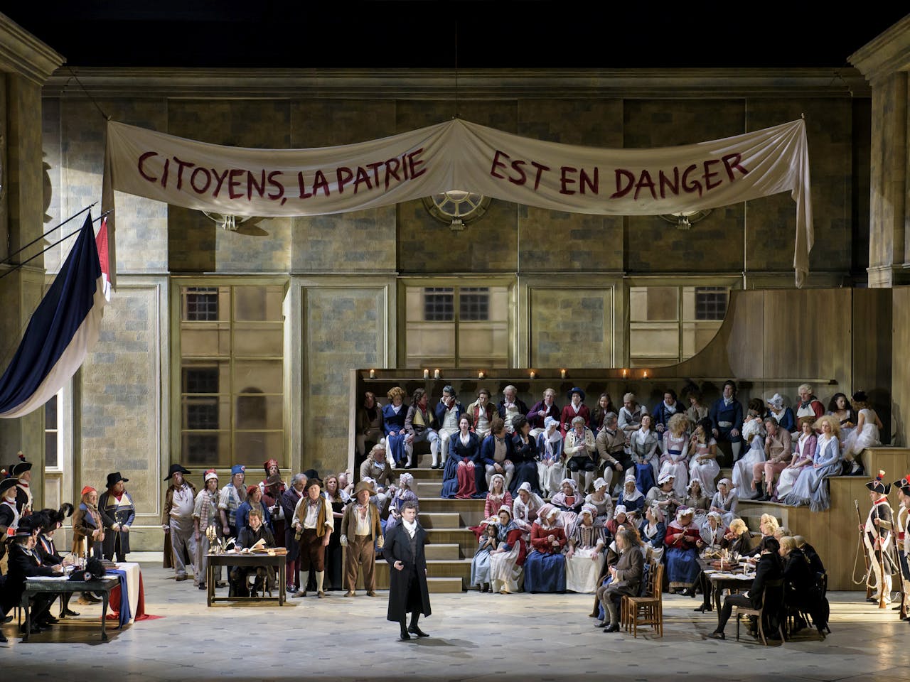 The cast of Andrea Chénier performing onstage at the Royal Opera House.