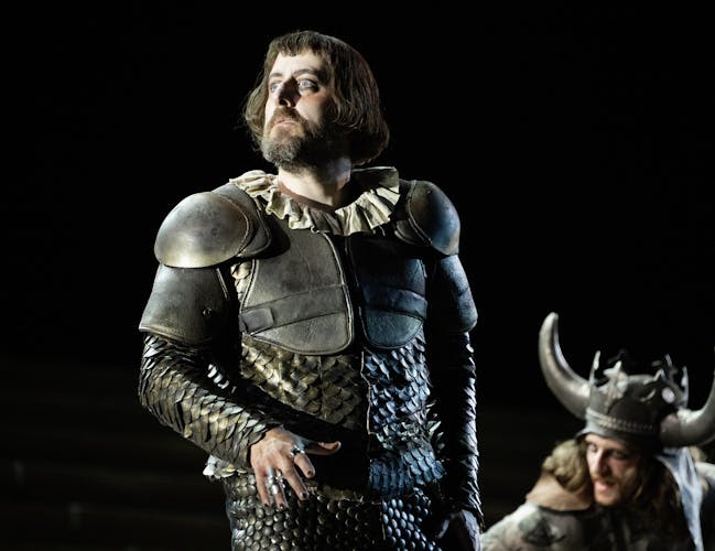 A cast member of Il Trovatore standing onstage during a performance.
