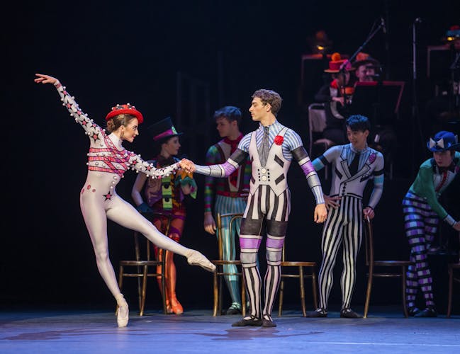 A male and female dancer in brightly-coloured costumes perform together.