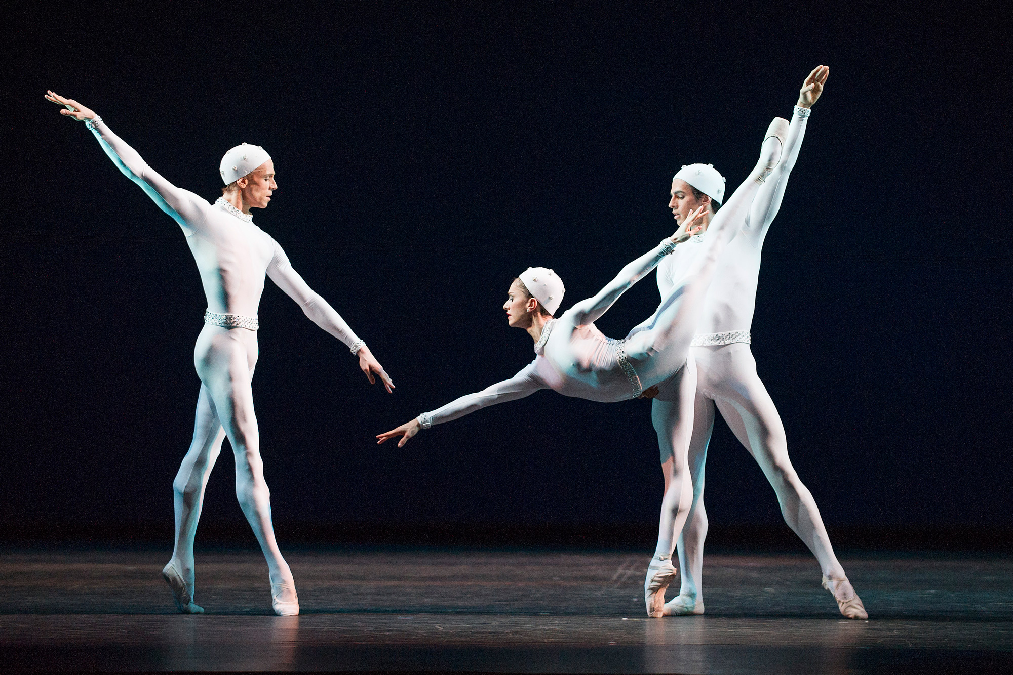 Three dancers in space-suit type costumes perform