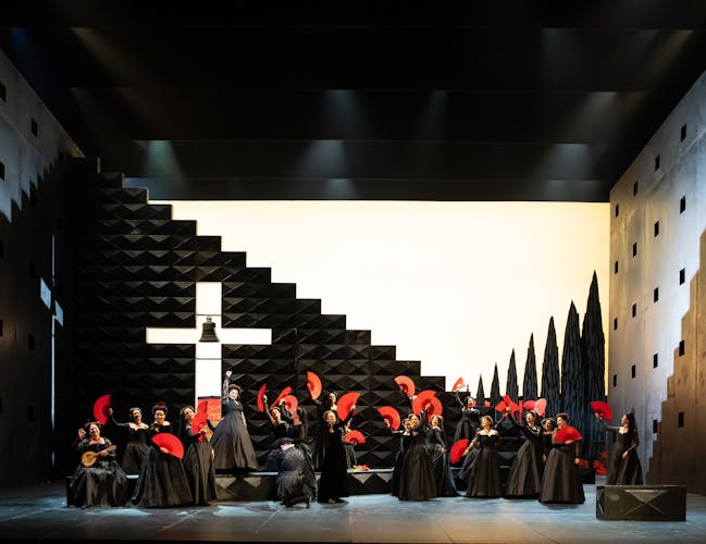 The cast of The Royal Opera production of Don Carlo performing onstage.