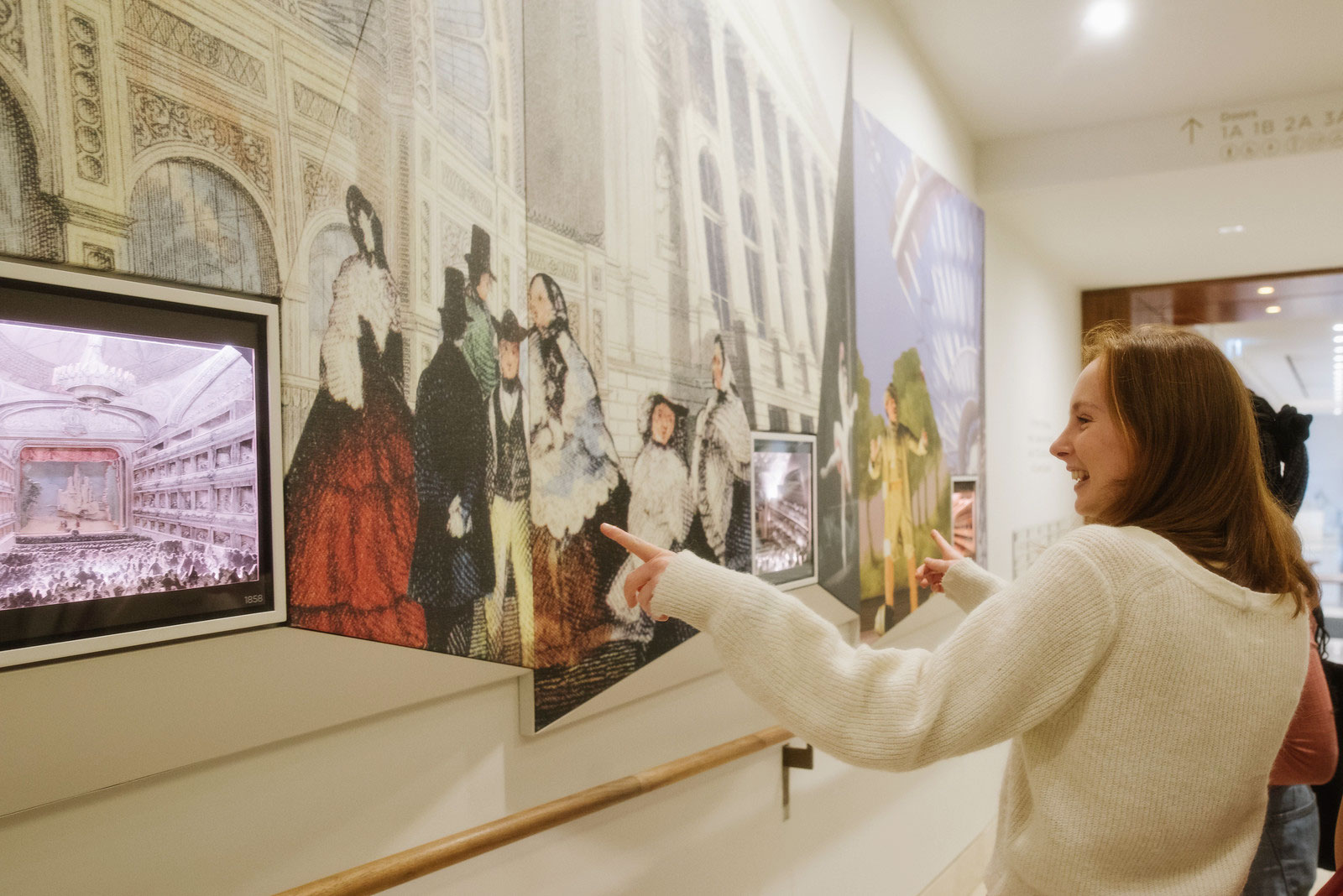 Two people pointing out details on a tour of the Royal Opera House.