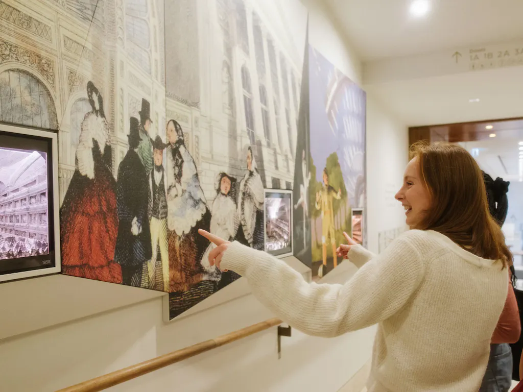 Two people pointing out details on a tour of the Royal Opera House.