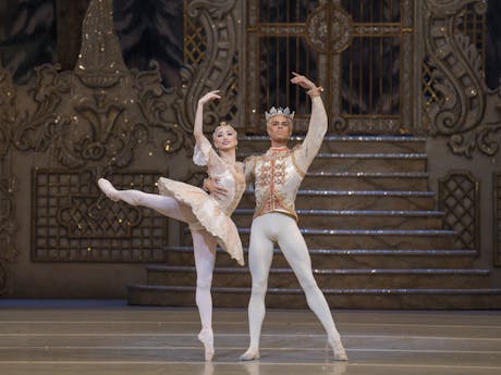 Two ballet dancers perform onstage in a production of the Nutcracker.