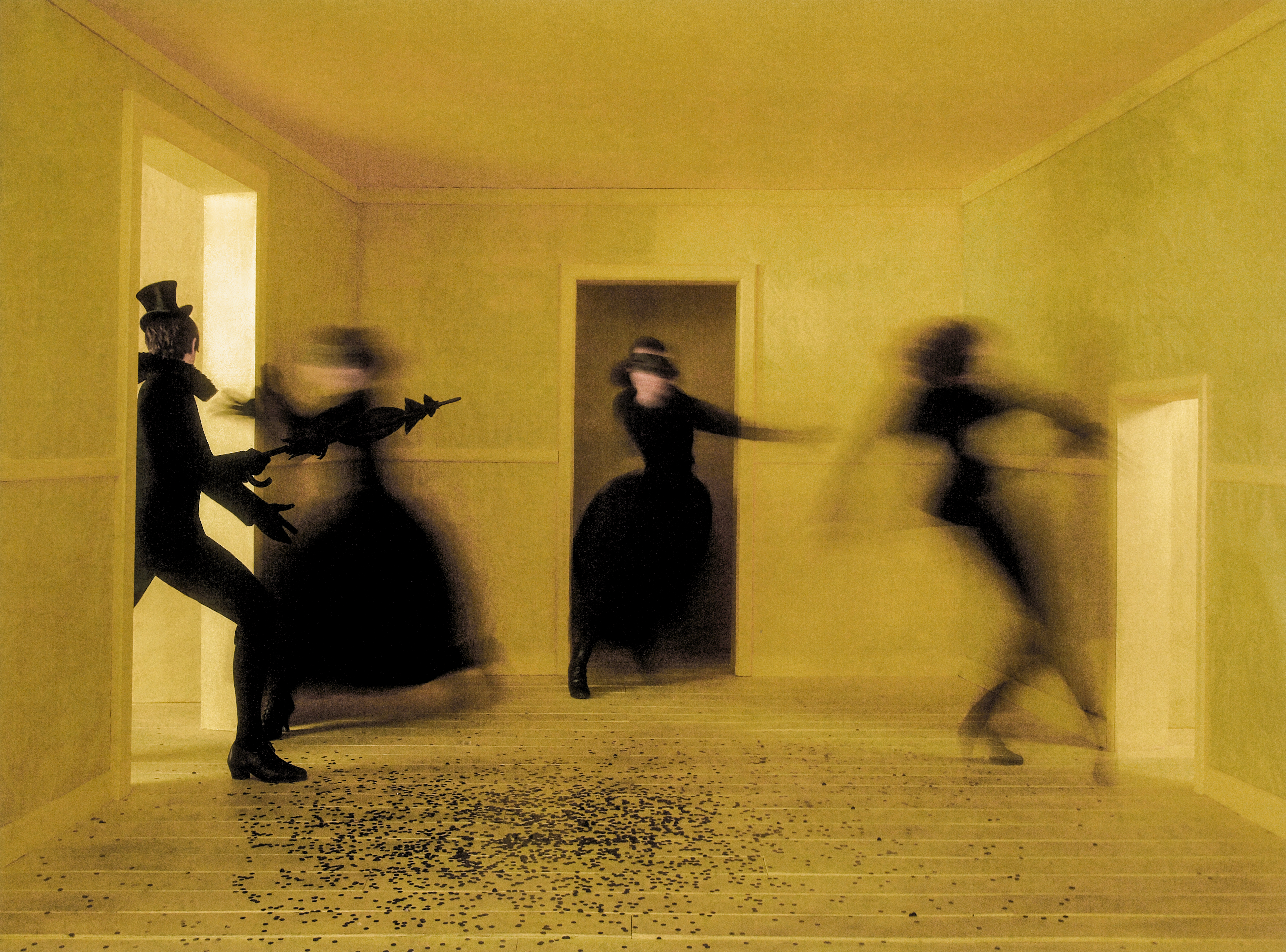 Dark figures appear as shadows in a yellow room. One of them holds a red envelope containing an invite. (3 of 4)