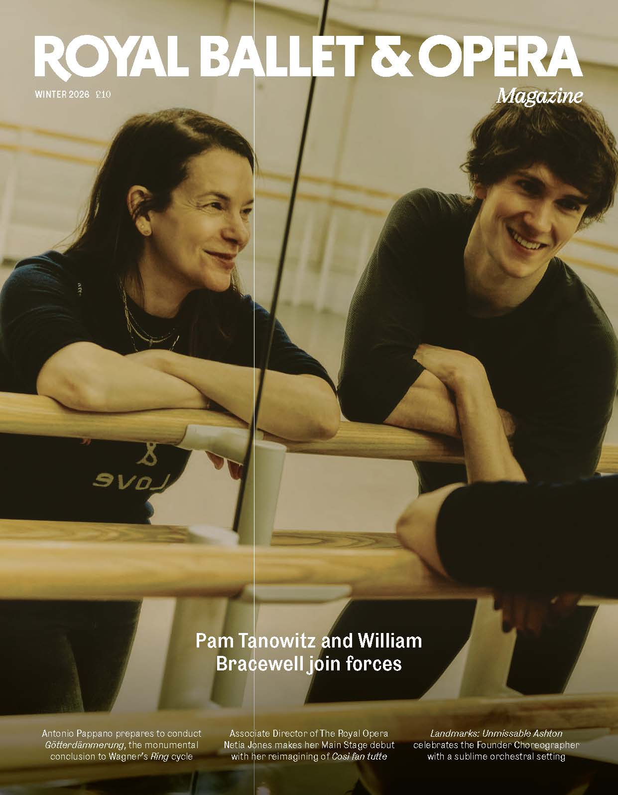 Two people lean against a barre in a well-lit ballet studio, reflected by the mirror. It is an image from the front cover of the Royal Ballet and Opera Autumn/Winter magazine featuring Royal Ballet dancer William Bracewell and choreographer Pam Tanowitz.