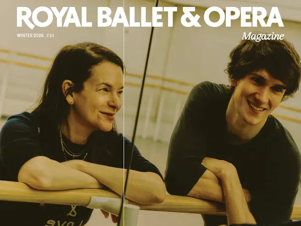 Two people lean against a barre in a well-lit ballet studio, reflected by the mirror. It is an image from the front cover of the Royal Ballet and Opera Autumn/Winter magazine featuring Royal Ballet dancer William Bracewell and choreographer Pam Tanowitz.