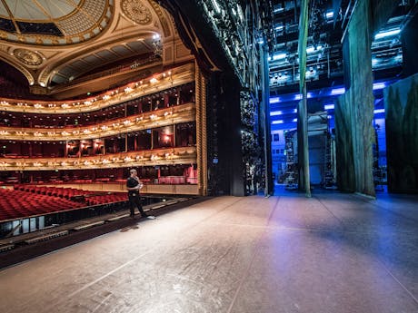 View from side stage: the red and gold auditorium seats are on the left and the purple backstage lights and wings are on the right