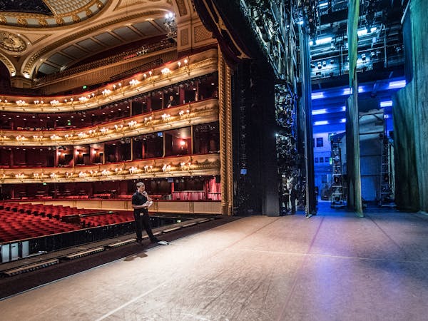 View from side stage: the red and gold auditorium seats are on the left and the purple backstage lights and wings are on the right