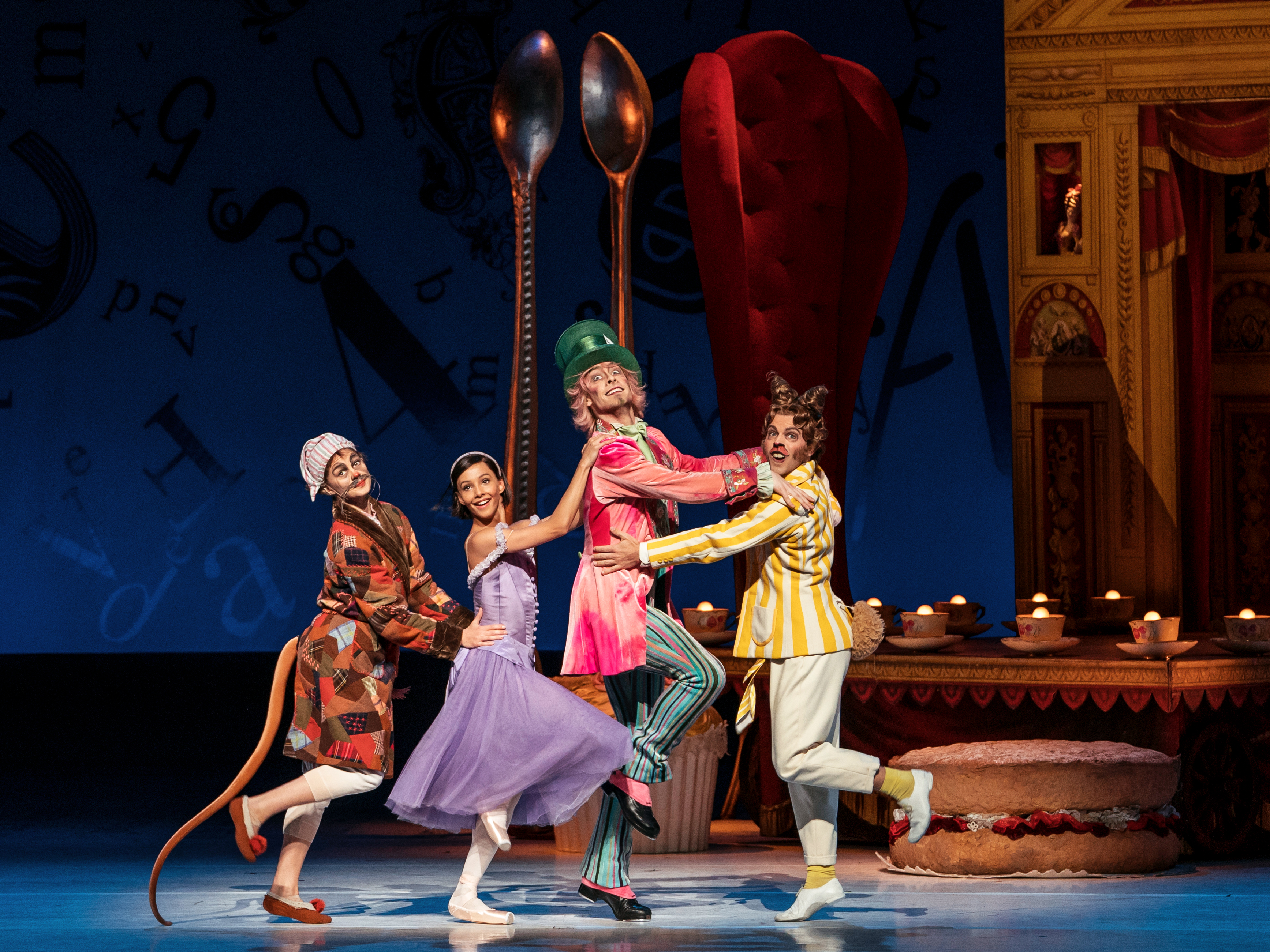 Two creatures, a man in a top hat and a girl in a purple dress dance together, holding each others shoulders.