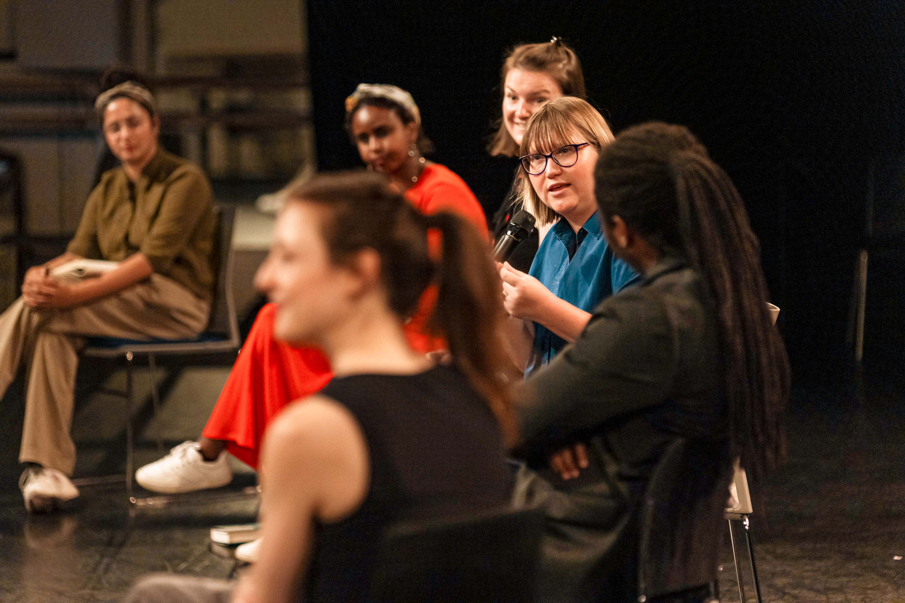A group of people sit and have a discussion.