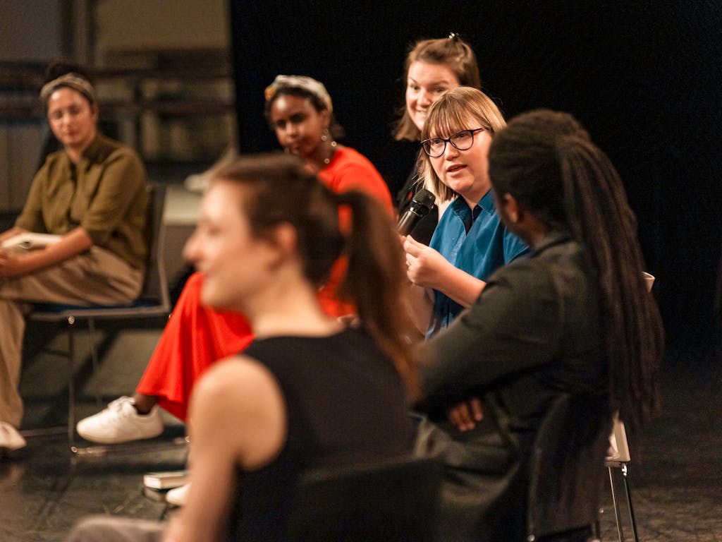 A group of people sit and have a discussion.