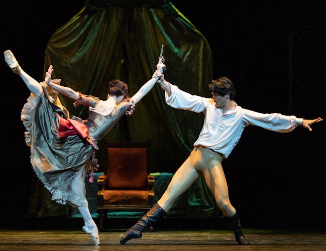 A woman with a gun lurches towards a man