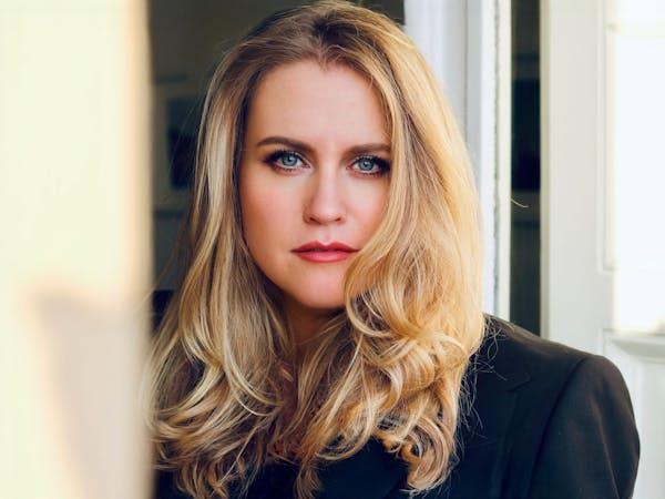 The Soprano Rachel Willis-Sørensen wears her long blonde hair down and stares at the camera wearing a black jacket.