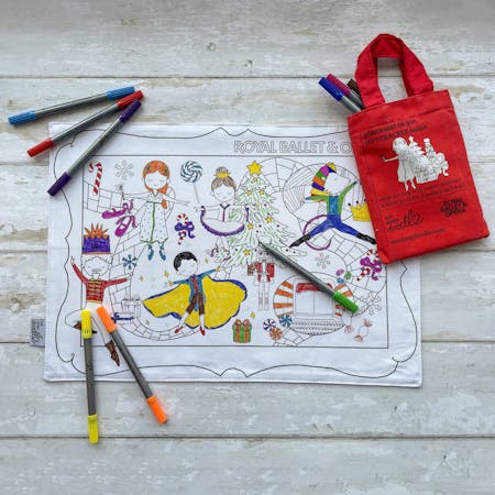 A white colouring sheet with coloured pens and a red bag