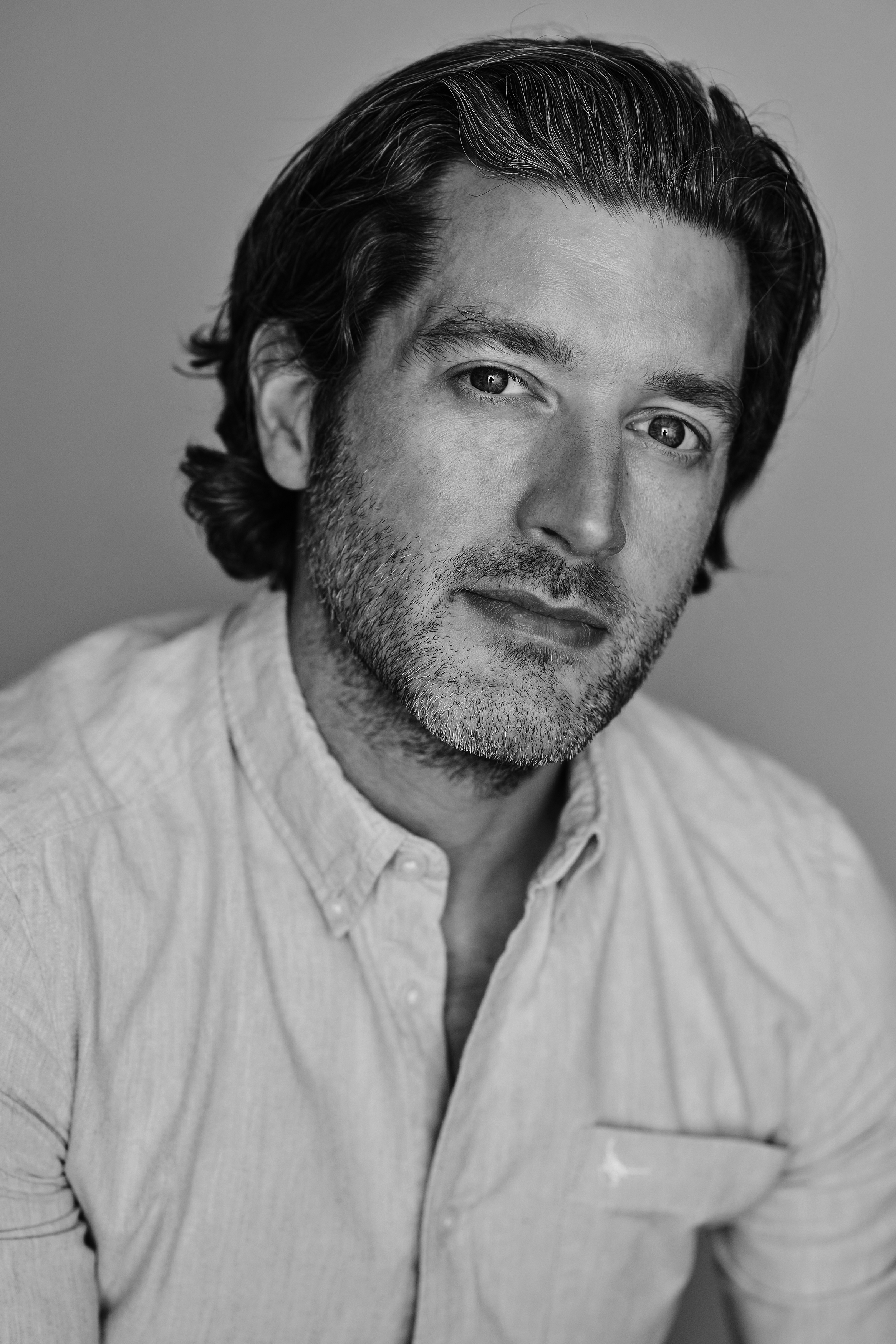 A black and white headshot of the video designer Duncan McLean. They wear a white shirt.