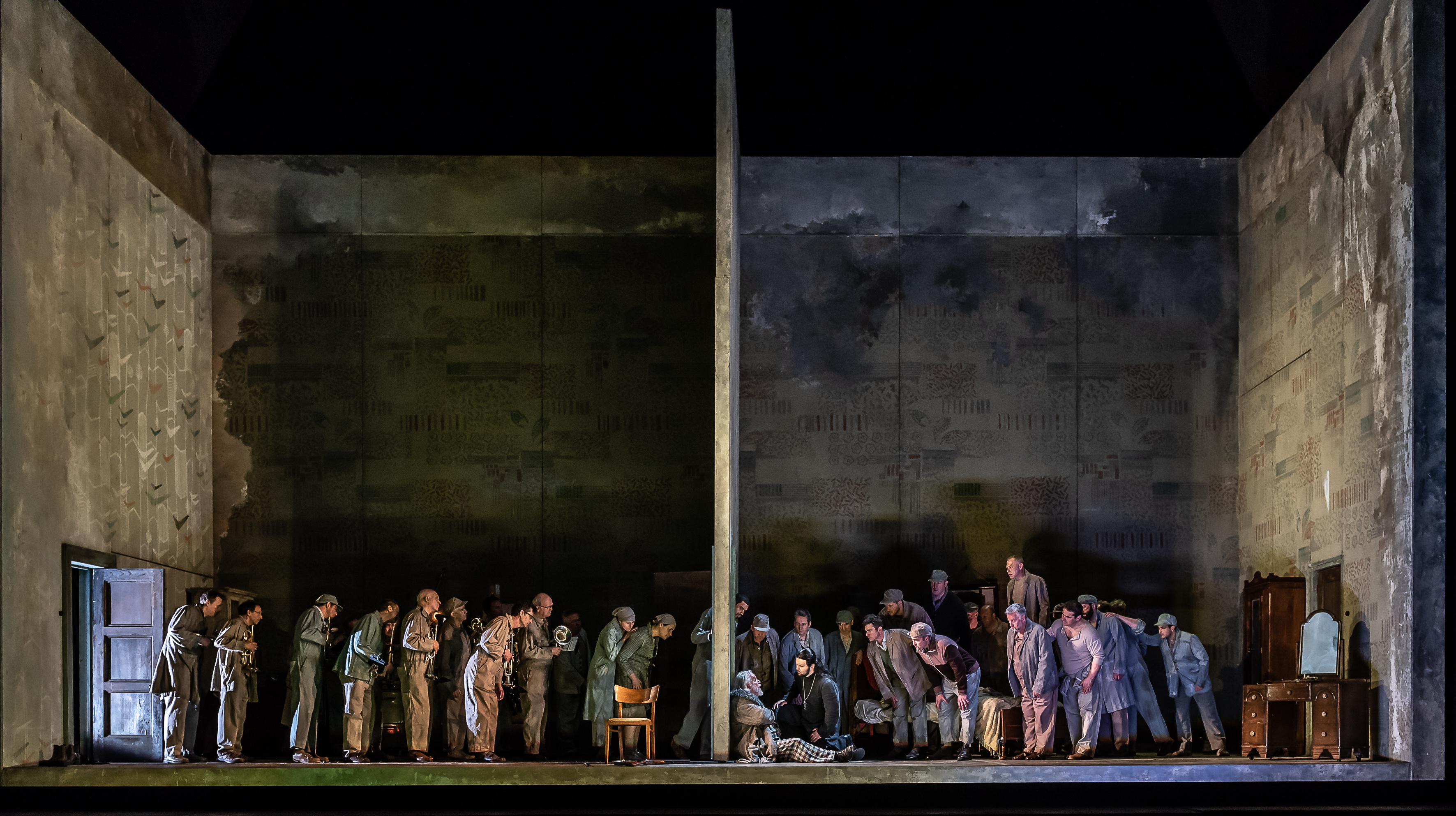 A group of people stand around a woman who is slumped against a wall. 