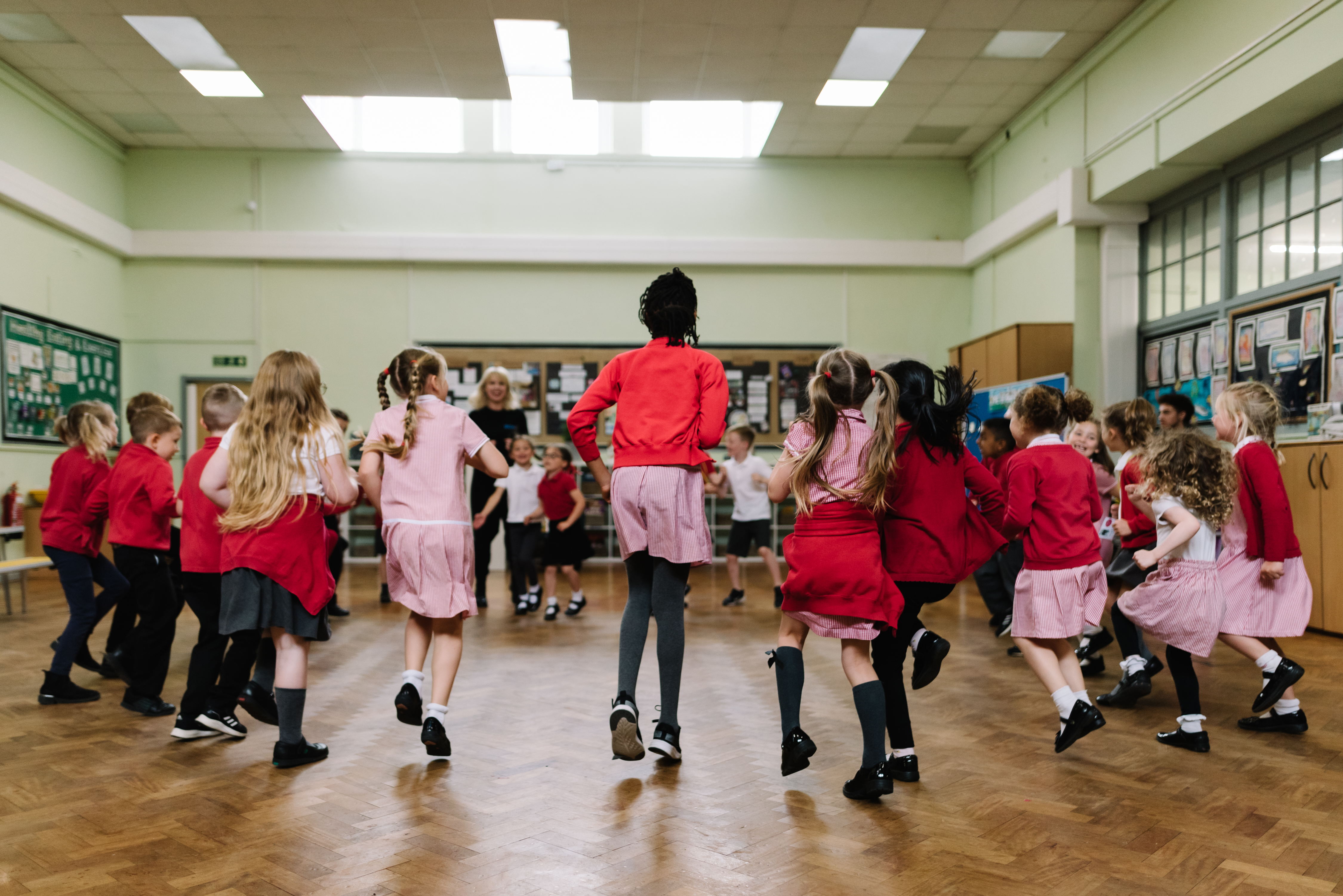 A group of school children dance in a circle as part of the Royal Ballet and Opera's Create and Dance programme.