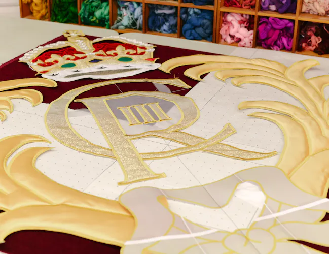 King Charles III's insignia for the new Royal Opera House stage curtains lay on a table at the Royal School of Needlework. (3 of 3)