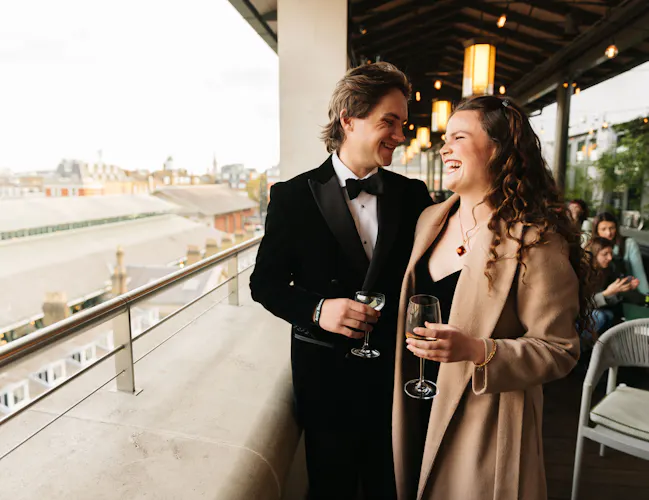 Two people in smart evening-wear look out over the piazza of Covent Garden. (9 of 9)