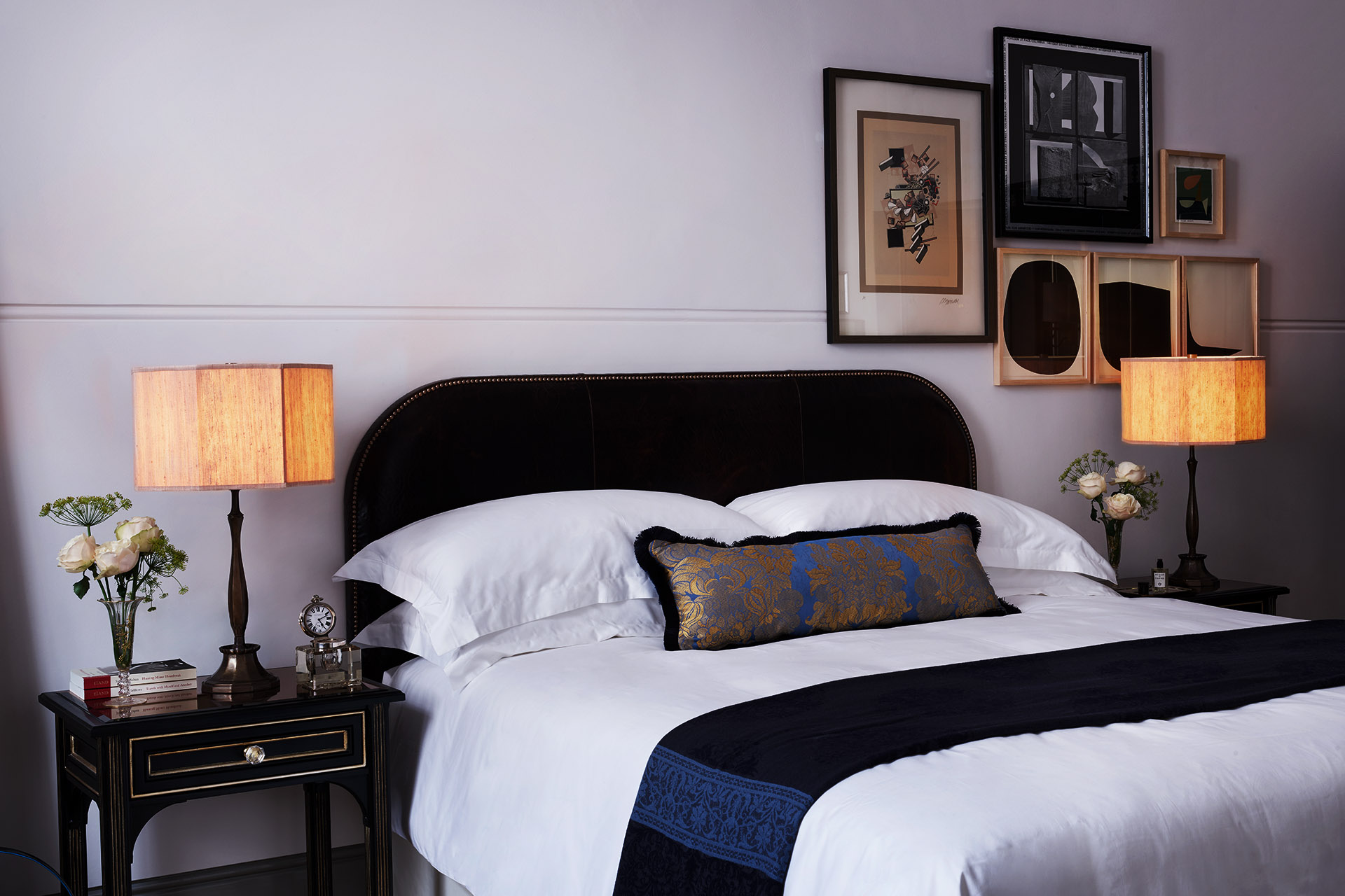 A black velvet bed with white and navy blue bedding.